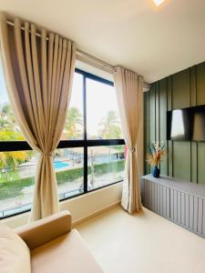 a bedroom with a large window and a television at Ocean Porto Flats in Porto De Galinhas