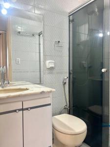 La salle de bains est pourvue de toilettes et d'une douche en verre. dans l'établissement Ap de 2 q, 70 metros, em bairro nobre e central, à Goiânia