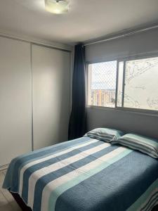 1 dormitorio con 1 cama y ventana en Ap de 2 q, 70 metros, em bairro nobre e central, en Goiânia