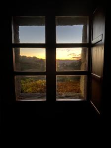 una ventana abierta con vistas a la puesta de sol vista a través de ella en Habitación deluxe con chimenea y baño en casa de campo. Piscina y jardín. en Amoeiro