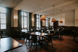 - une salle à manger avec des tables, des chaises et des fenêtres dans l'établissement Château de Looz, à Looz