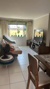 un soggiorno con un divano e un tavolo di Lar do Viajante: Apartamento 2 quartos a 300m da praia em Manaíra a João Pessoa