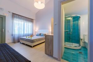 a bedroom with a bed and a glass shower at Terra di Olive Thassos in Potos