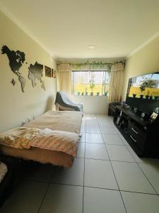 una camera da letto con un letto e una TV a schermo piatto di Lar do Viajante: Apartamento 2 quartos a 300m da praia em Manaíra a João Pessoa