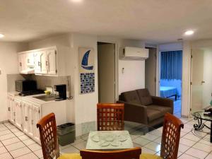 a kitchen and living room with a couch and a table at 302 Excelente apto muy Cerca de Playa in Mazatlán