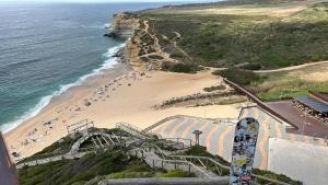 a view of a beach with a slide and the ocean at Beach Glove Ericeira II in Ericeira