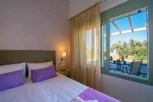 a bedroom with a bed and a window with a table at Terra di Olive Thassos in Potos