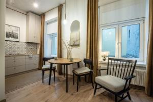 a kitchen and dining room with a table and chairs at Apartament Gold Próchnika 9 in Łódź