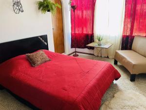 1 dormitorio con cama roja y sofá en Hotel Boutique Tesoro, en Sevilla
