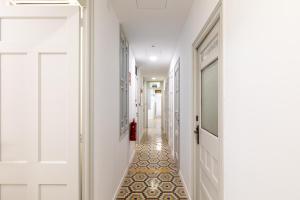 a hallway with a tile floor and white walls at Pensión Alicante by Moontels in Valencia