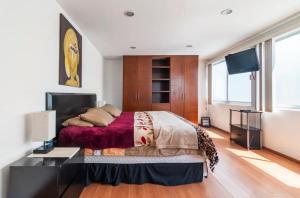 ein Schlafzimmer mit einem großen Bett und einem TV in der Unterkunft Casa grande y cómoda! Súper ubicación - Angelópolis in Puebla