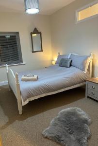 a bedroom with a bed with a mirror and a rug at City Of Chester Award Winning Cottage -Pixie Terrace Chester in Chester