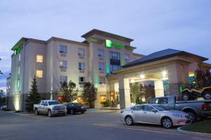 a hotel with cars parked in a parking lot at Holiday Inn & Suites Lloydminster, an IHG Hotel in Lloydminster
