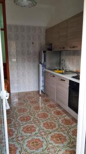 una cucina con pavimento piastrellato e una cucina con lavandino di Appartamento Ruffano a Ruffano