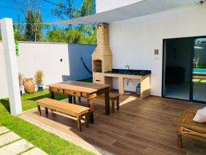 um pátio com uma mesa de pingue-pongue e bancos em Casa com piscina exclusiva em Cabo Frio