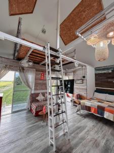 a room with two bunk beds and a ladder at The 99 Cottage (บ้านทุ่งบางปลาม้า) in Suphan Buri