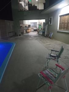 een kamer met 2 stoelen en een zwembad bij Vanessa pousada familiar in São Gabriel