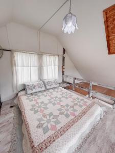 1 dormitorio con 1 cama con edredón en The 99 Cottage (บ้านทุ่งบางปลาม้า) en Suphan Buri