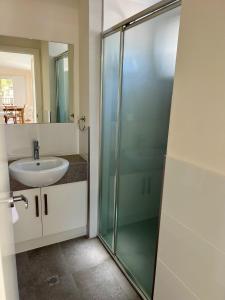 a bathroom with a glass shower and a sink at Esperance Pink Lake Tourist Park in Esperance