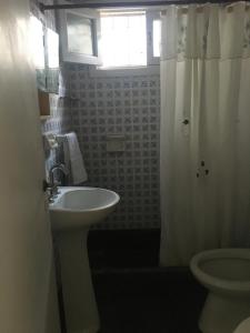 ein Bad mit einem Waschbecken, einem WC und einem Fenster in der Unterkunft Silvestre in Mar del Plata