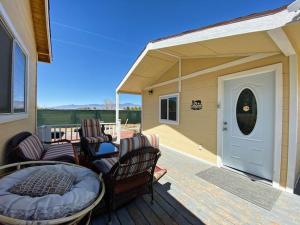 a porch with chairs and a bed on a deck at Sun Tiny House D Pahrump in Pahrump