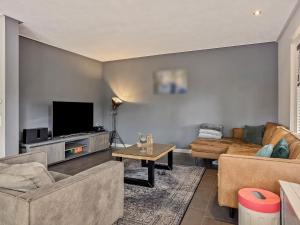 a living room with two couches and a flat screen tv at Holiday home with a garden and parking in Drachten