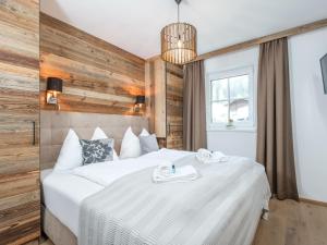 a bedroom with a large white bed with towels on it at Tauernlodge Liz in Mühlbach am Hochkönig