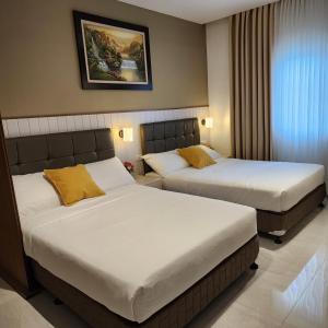 Habitación con 2 camas en una habitación de hotel en Twin hearts 328, en Roxas City