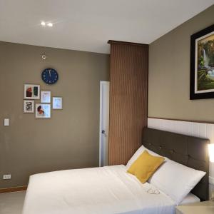 1 dormitorio con 1 cama y reloj en la pared en Twin hearts 328, en Roxas City