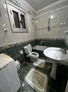 ein Badezimmer mit einem Waschbecken, einem WC und einer Badewanne in der Unterkunft برج العزيزية بانوراما بحر للعائلات فقط in Alexandria