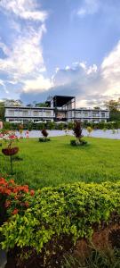 um edifício com um campo de relva e flores em Hotel Capri Doradal em Doradal