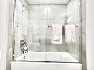 y baño con bañera, ducha y toallas. en NEW One Bedroom Penthouse, Silver Lake + Parking! en Los Ángeles
