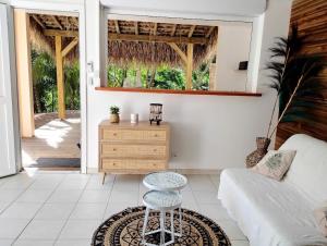 a living room with a couch and a table at Studio Ti Kaye avec Jacuzzi in Les Trois-Îlets