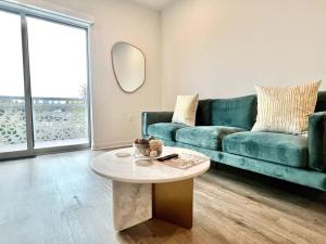 sala de estar con sofá verde y mesa en NEW One Bedroom Penthouse, Silver Lake + Parking!, en Los Ángeles