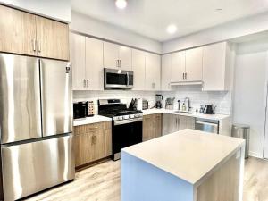 una cocina con electrodomésticos de acero inoxidable y armarios de madera en NEW One Bedroom Penthouse, Silver Lake + Parking! en Los Ángeles