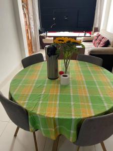 une table avec un tissu de table vert et orange et des fleurs. dans l'établissement the traveler's house "Airb nb and travel", à Cusco