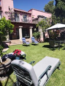 - un jardin avec des chaises, une table et un parasol dans l'établissement Villa Orbayu B&B Boutique, à Cuernavaca