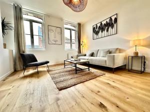 un soggiorno con un divano e un tavolo di L'Eclat Prestigieux : Quartier Henriville ad Amiens