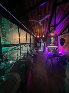 a room with tables and chairs and purple lights at Doc May Boutique Villa in Da Lat