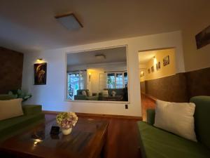 a living room with green furniture and a large mirror at Doc May Boutique Villa in Da Lat