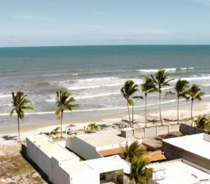 een uitzicht op een strand met palmbomen en de oceaan bij Viva Mar - suítes in Canavieiras