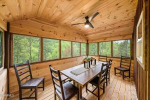 a dining room with a table and chairs at Cabin Coco - June sale dates! Luxe A Frame with projector screen, arcade and swim spa in Sevierville