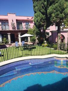 - une piscine dans une cour avec une table et un parasol dans l'établissement Villa Orbayu B&B Boutique, à Cuernavaca