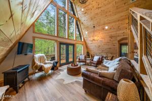 a living room with a couch and a tv in a cabin at Cabin Coco - May sale dates! Luxe A Frame with projector screen, arcade and swim spa in Sevierville