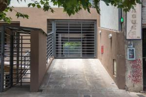 una puerta de garaje con una puerta en el lateral de un edificio en Buena ubicación de monoambiente en General Sarmiento