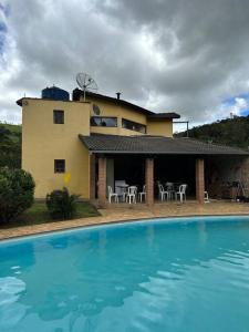 een huis met een zwembad voor een huis bij Casa de campo aconchegante in Córrego do Bom Jesus
