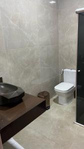 y baño con aseo y lavamanos. en Villa'S Roraima - Pousada & Natureza, en Boa Vista