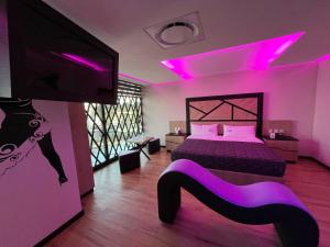 a bedroom with a bed with pink lights on it at Hotel City Lights in Mexico City