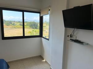 um quarto com uma grande janela e uma televisão de ecrã plano em Vista Mar em San Carlos