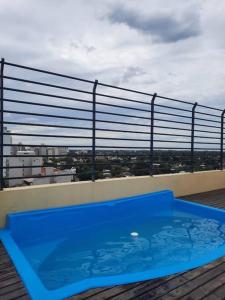 una piscina azul en la azotea de un edificio en Monoambiente en Muñiz en 